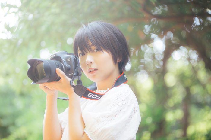 こちらに振り向くカメラマンの女性写真